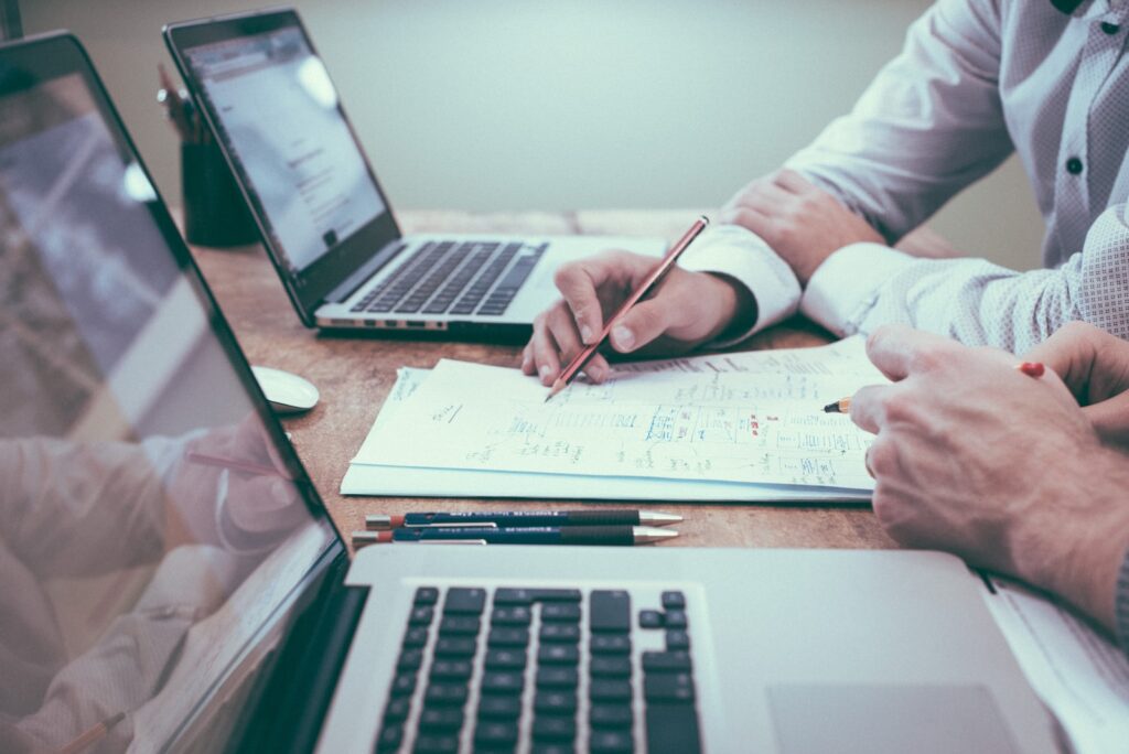 person holding pencil near laptop computer doing a digital marketing strategy